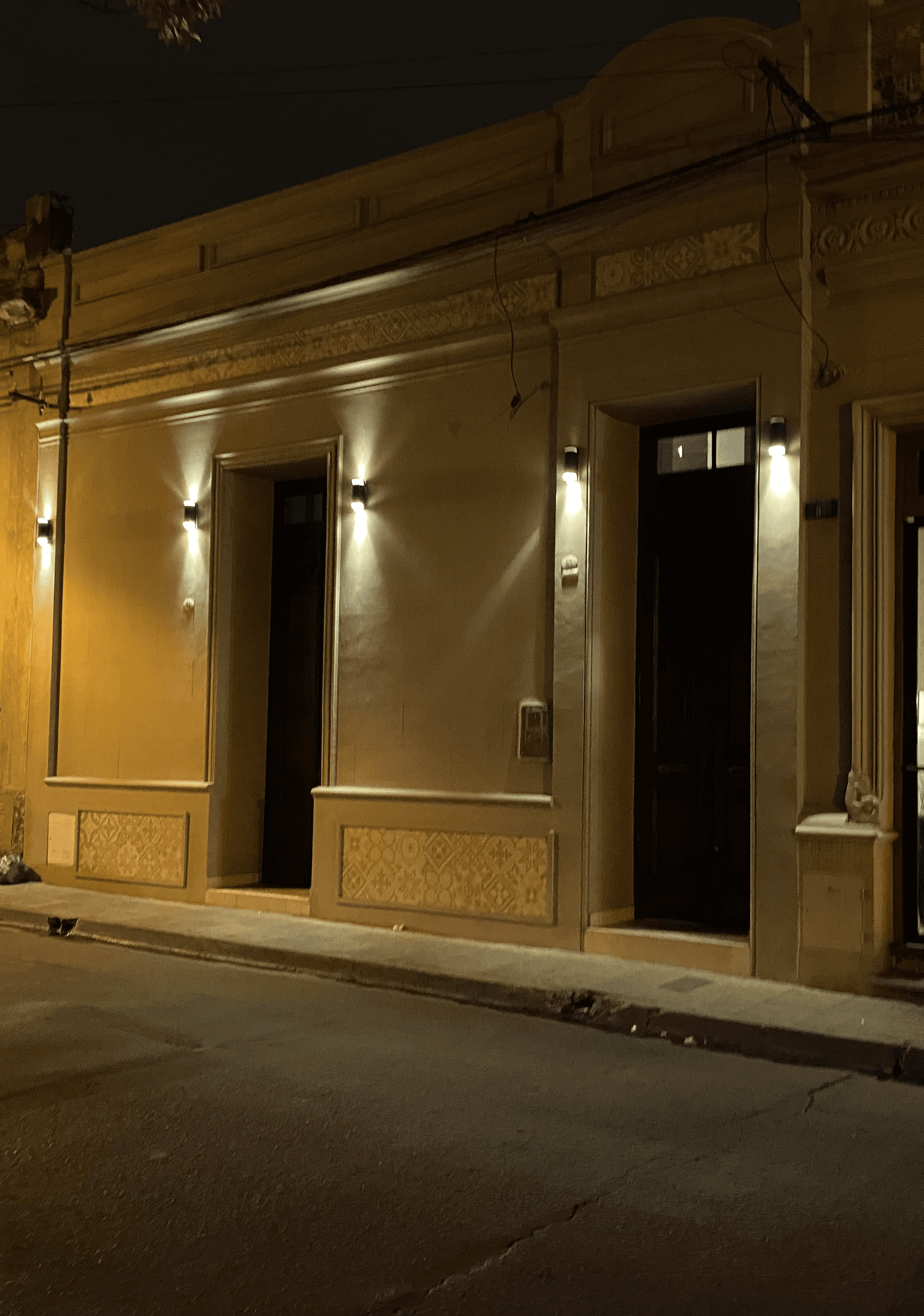 Fachada de Departamentos Muskuy iluminada de noche